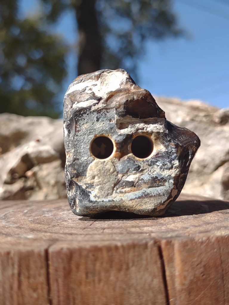 chunk of junk rock with drilled out eyes and a penetrating stare