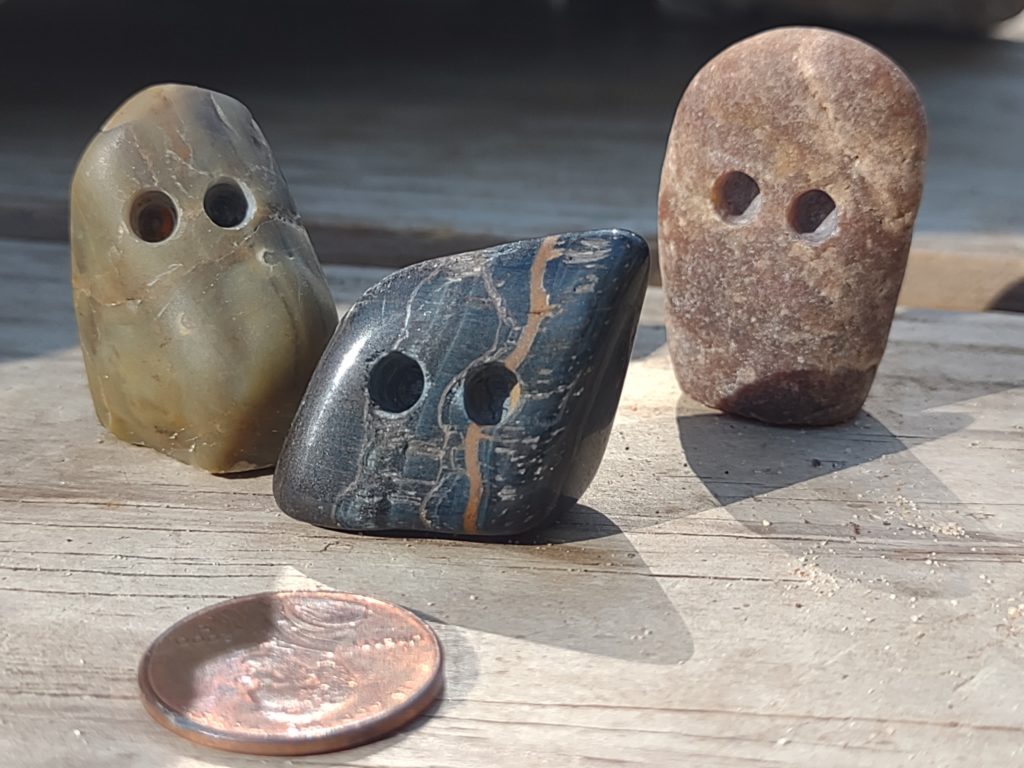 Trio of rocks with drilled out eyes and seams for expressive mouths